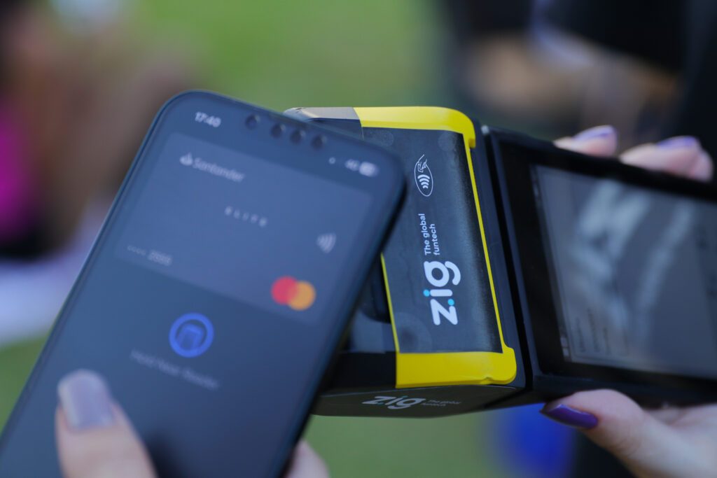 Smartphone aproximando de PDV Zig para encerrar conta no pós pago.
